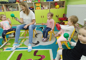 opiekunka gra na instrumentach i dzieci obok niej