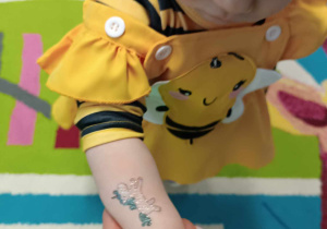 dziewczyna pokazuje rączkę, na której ma tatuaz