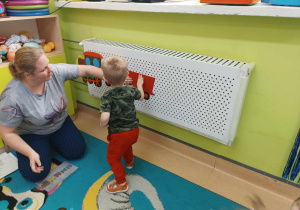 chłopiec wraz z opiekunką przykleja wagon do pociągu