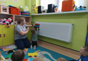 dziewczynka wraz z opiekunką przykleja do grzejnika lokomotywę