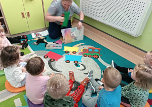 opiekunka pokazuje dzieciom rozsypankę obrazkową