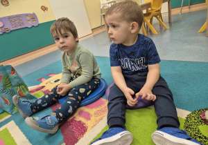chłopcy siedzą na dywanie