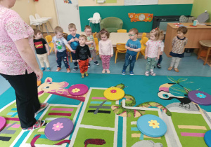 dzieci stoją w jednej linii i słuchają instrukcji zabawy ruchowej