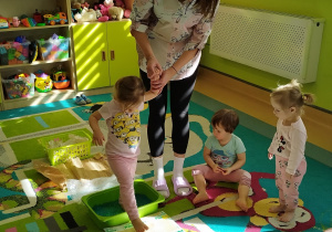 opiekunka trzyma dziewczynkę za rękę kiedy ta przechodzi po ścieżce
