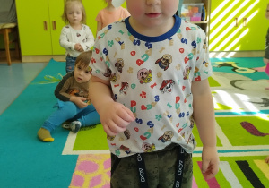 chłopiec stoi z wiankiem na głowie