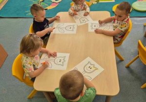 dzieci przy stoliku kolorują wydrukowane tulipany