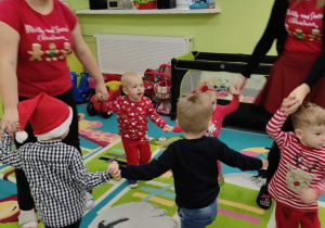 dzieci tańczą z opiekunkami w koło