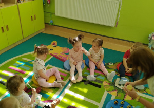 dzieci na dywanie, dziewczynka próbuje miód z łyżeczki