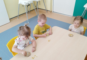 dzieci przy stoliku przyklejają makaron