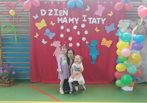 mama z córeczkami pozuje do zdjęcia
