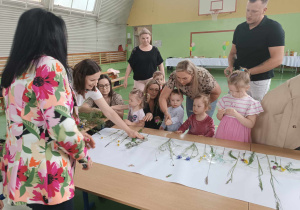 dzieci i rodzice robią pracę plastyczną, pani dyrektor się przygląda