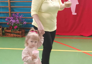 dziewczynka z mamą niosą napoje