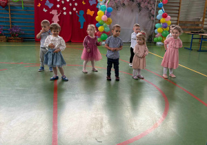 dzieci stoją na środku sali