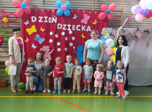dzieci z opiekunkami , pania dyrektor i pani burmistrz stoją i pozują do zdjęcia