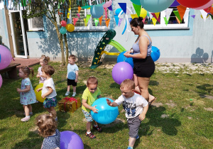 opiekunka rozdaje balony dzieciom