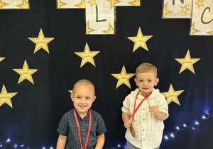dwóch chłopców z medalami na szyi ,