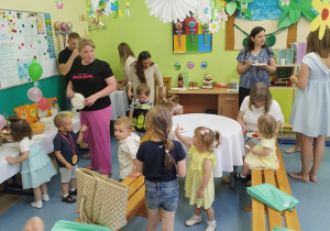 rodzice i dzieci częstują się słodkościami ze stołów
