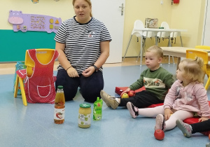 opiekunka pokazuje produkty, które można zrobić z jabłek