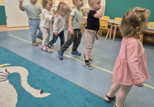 dzieci idą okrakiem