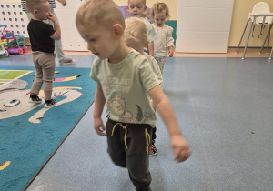 chieci chodzą jedno za drugim po linii opiekunka patrzy