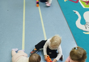dzieci układają klocki na liniach na podłodze