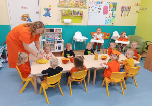 opiekunka rozdaje dzieciom przygotowaną masę dyniową do zabawy