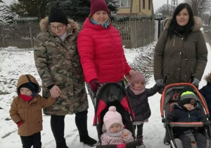 opiekunki i dzieci w wózkach stoją na chodniku