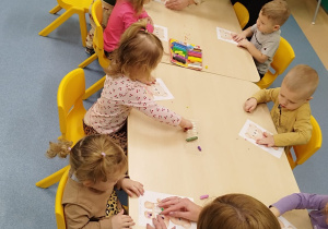 opiekunki pomagają dzieciom wykonać zadanie plastyczne