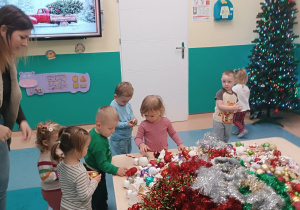 dzieci wybierają ozdoby, spośród tych leżących na stoliku