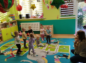 dzieci i opiekunki rzucają papierowe kulki