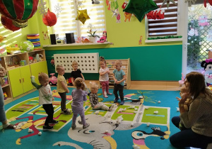 dzieci i opiekunki rzucaja papierowe kulki