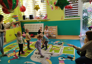 dzieci i opiekunki rzucaja papierowe kulki