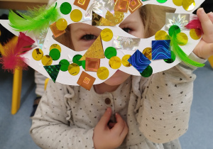 dziewczynka patrzy przez zrobioną maskę