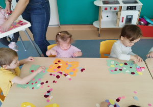 dzieci przy stoliku ozdabiają motyle