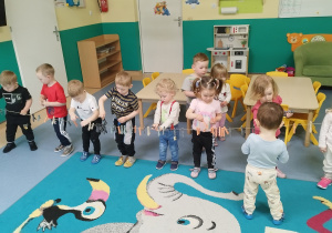 dzieci stoją wzdłuż sznurka na którym zapięte są spinacze