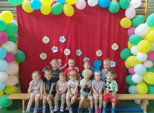 dzieci siedzą na ławce , a niektóre stoją