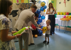 chłopiec trzyma piłkę, przybija piątkę panu burmistrzowi