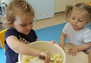 dziewczynka trzyma łyżkę i miesza w misce