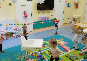 dzieci zbierają i przyklejają piłki
