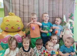 dzieci ustawione na ściance z tłem w pisanki, uśmiechają się