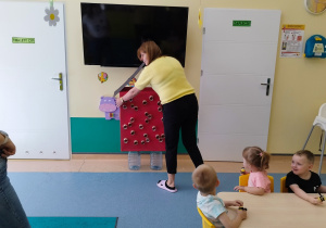 opiekunka wnosi do sali kartonowy ul