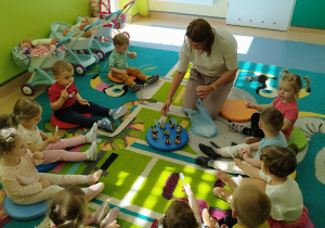opiekunka częstuje dzieci miodem, niektóre dzieci trzymają łyżeczki