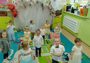 dzieci stoją na dywanie uśmiechają się