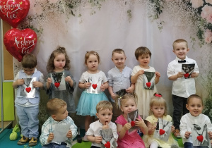 dzieci stoją na tle i trzymają prezent
