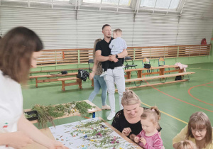 dzieci i rodzice przyklejają do kartonu