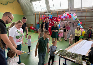 rodzice i dzieci dochodzą do stolików, przy których będą robić pracę