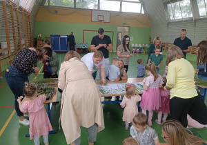 dzieci wraz z rodzicami tworząpracę plastyczną