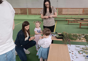panie i dziewczynki przyglądają sie położonym zbiorom z łąki