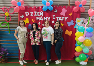opiekunki wraz z panią dyrektor pozują do zdjęcia na ściance