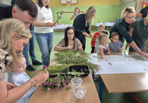 rodzice i dzieci przyklejają do kartonu trawy